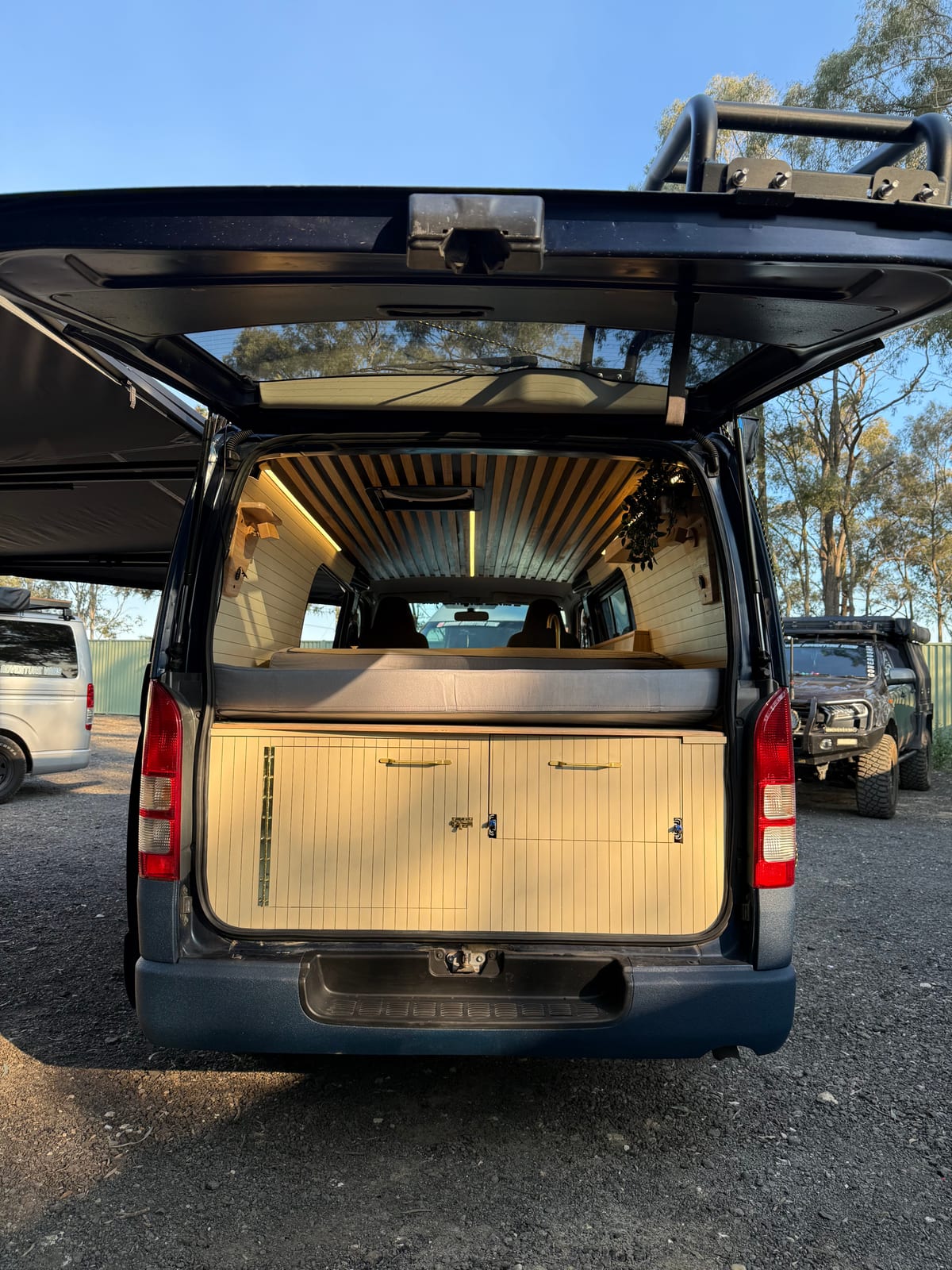 Navy 4×4 Hiace — Rear doors open onto the bed