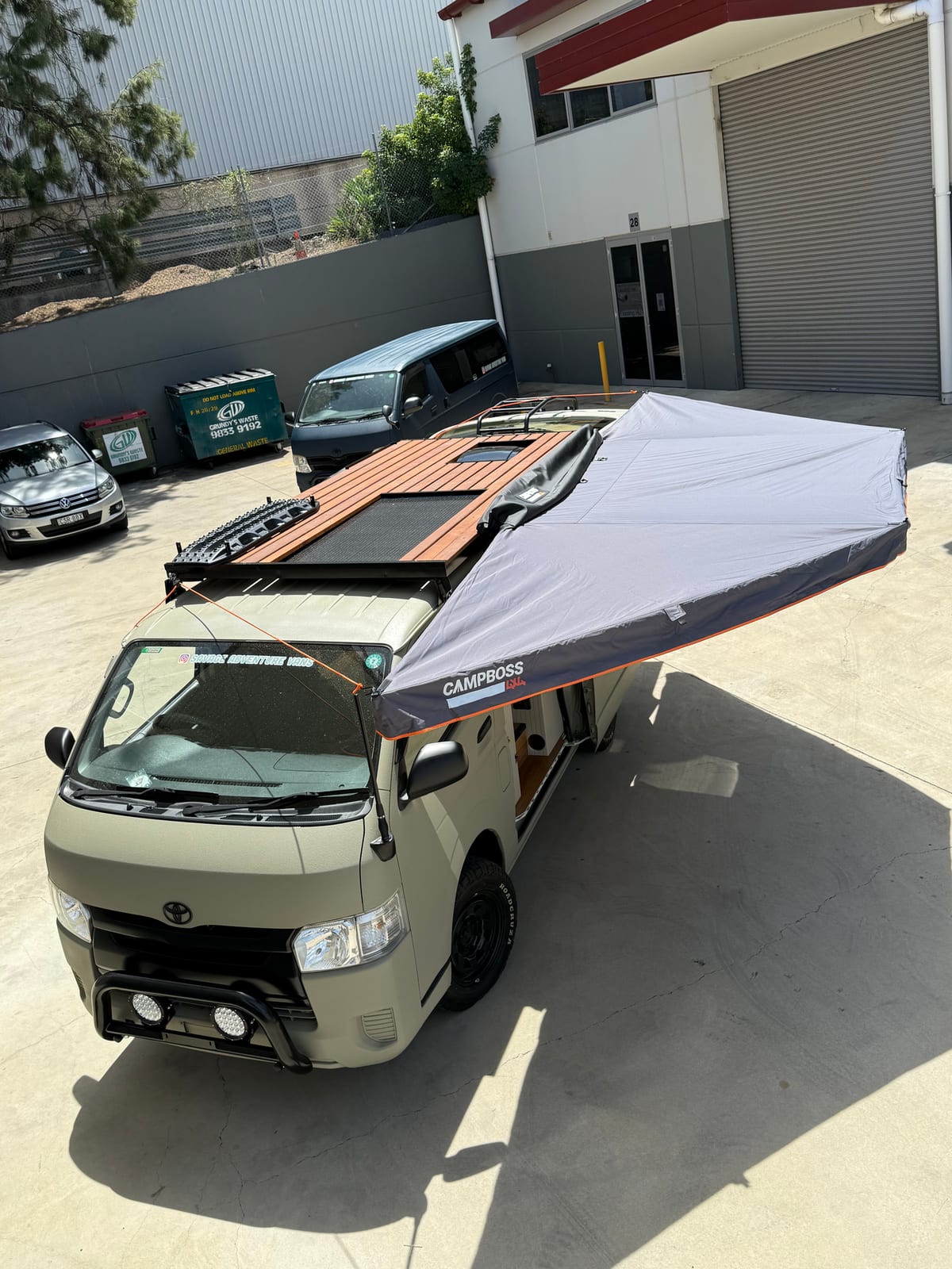 Sand Hiace — Awning open over the timber rack