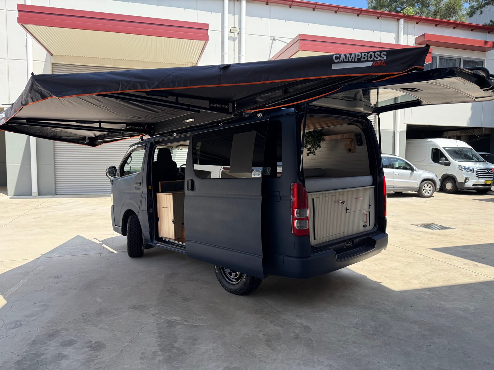 Slate Blue Hiace — Rear quarter under the awning